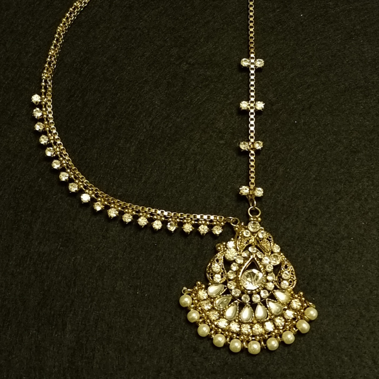 One sided maang tikka with kundan, stones and pearls.